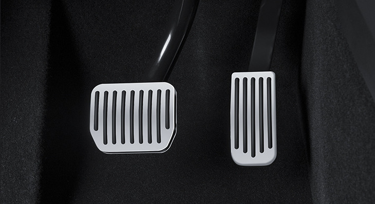 Tesla pedal area with silver and black pedal covers installed