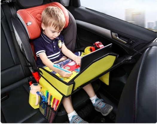 Child drawing on a kids travel tray in a car seat