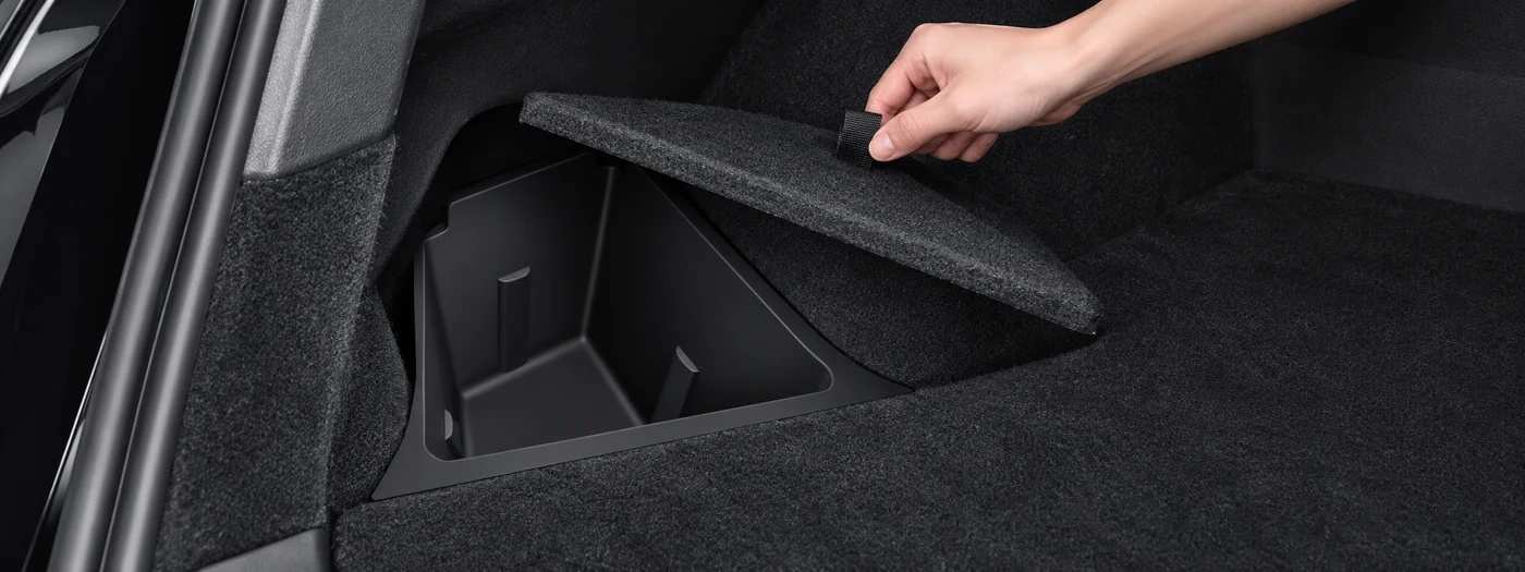 Pull-tab access for rear trunk storage bin