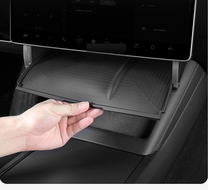 Hand opening the fold-down under-screen storage compartment