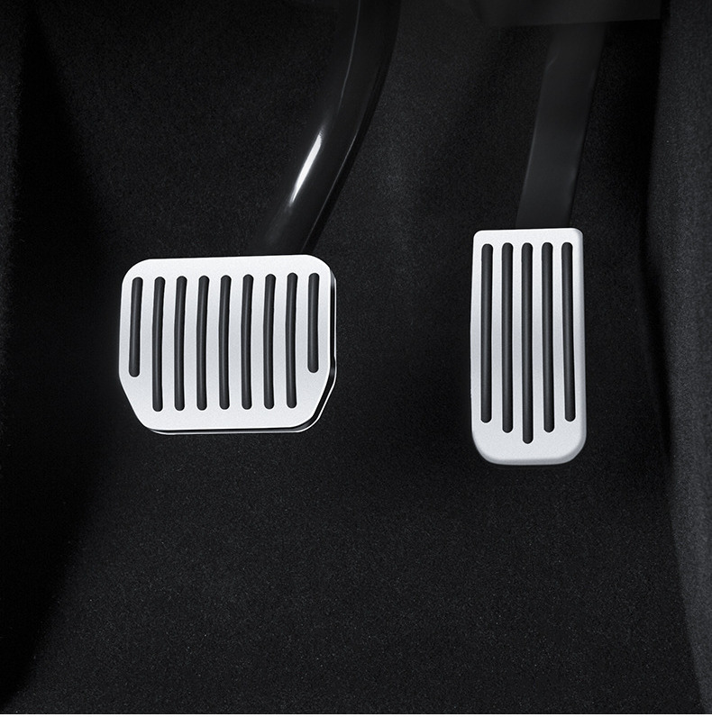 Installed brake and accelerator covers in a Tesla footwell