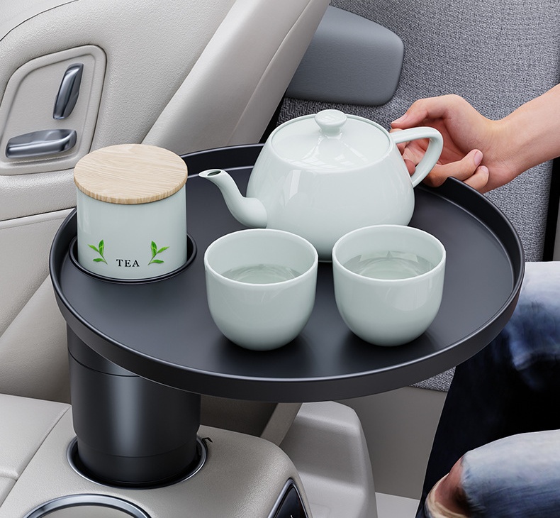 Round car cup holder tray holding tea inside a vehicle