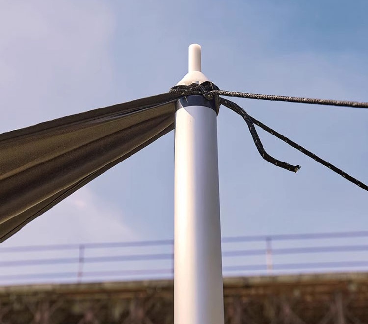 Awning fabric attached to aluminum support pole with guy lines