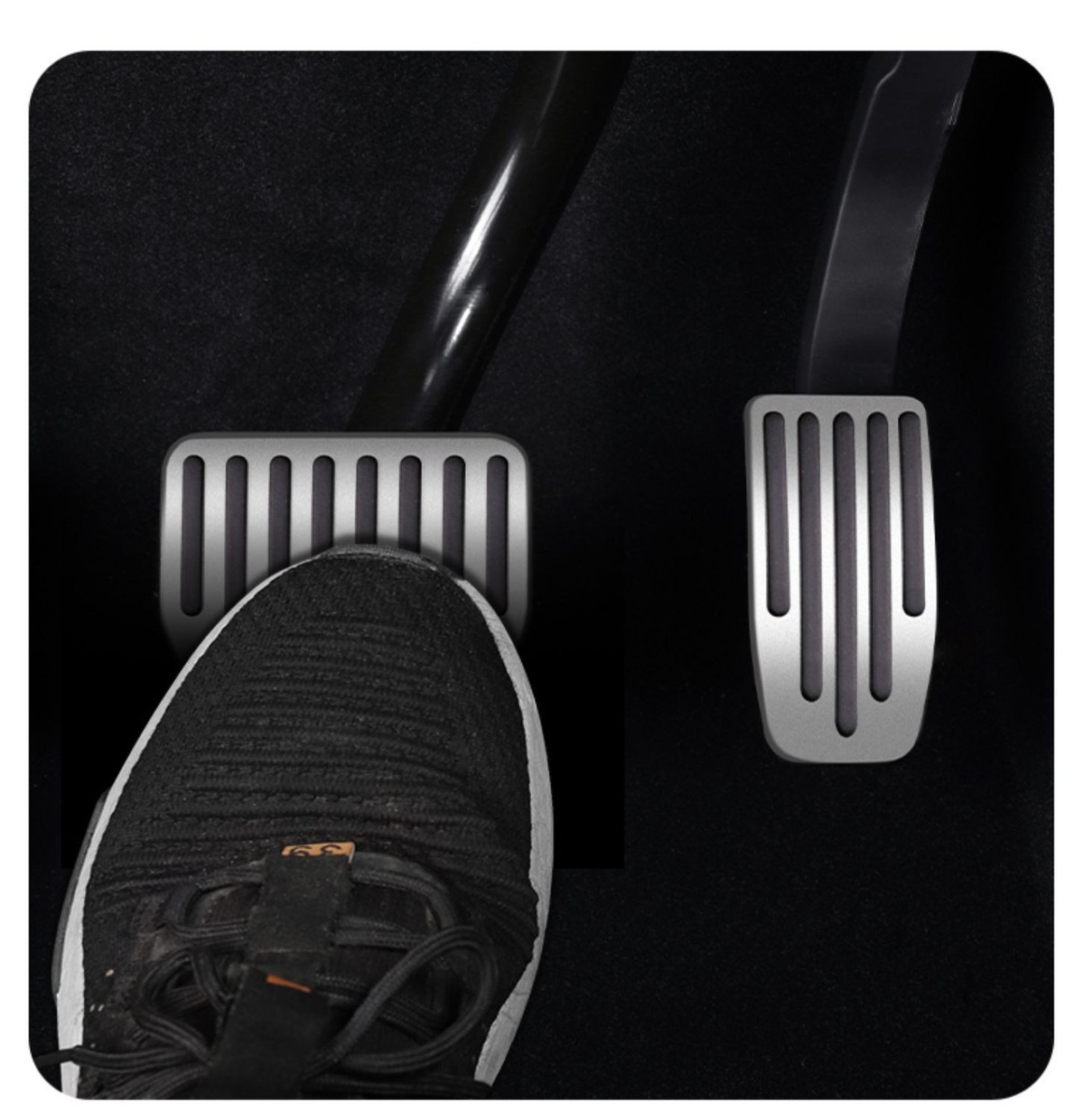 Driver shoe pressing a silver Tesla brake pedal cover
