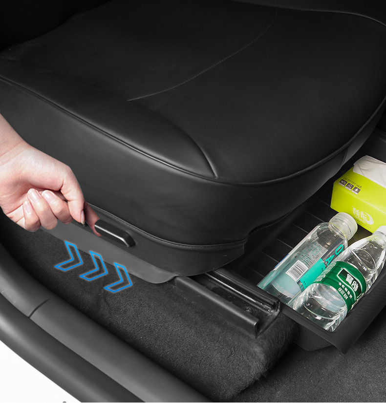 Under-seat storage tray sliding out from beneath a Tesla seat